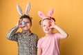 A boy with a girl with bunny ears hold Easter eggs in his hands