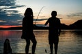 Children in silhouette, caught a small fish as sunsets across th Royalty Free Stock Photo