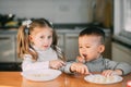 Boy and girl children in the kitchen eating sausages with pasta is very fun and friendly Royalty Free Stock Photo