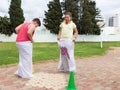 Boy and girl are competing in jumping in bags in the public park in Nahariya, Isarel