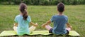 boy and a girl doing yoga, outdoors, sitting on Mat Royalty Free Stock Photo