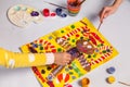 Boy And Girl Draw A Christmas Picture At Home. Children Paint A Gingerbread Man With Paints, Closeup