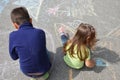 Boy and girl drawing with chalk home orphan child dream. children paint on the pavement. happy childhood on the street Royalty Free Stock Photo