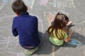 Boy and girl drawing with chalk home orphan child dream. children paint on the pavement. happy childhood on the street Royalty Free Stock Photo