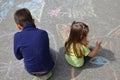 Boy and girl drawing with chalk home orphan child dream. children paint on the pavement. happy childhood on the street Royalty Free Stock Photo