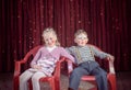 Boy and Girl Dressed as Clowns Sitting on Chairs