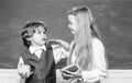 Boy and girl from elementary school at the school yard. Kid is learning in class on background of blackboard. Blackboard Royalty Free Stock Photo