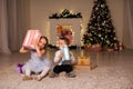 Boy and girl family opens Christmas gift new year holiday lights Christmas tree garlands Royalty Free Stock Photo