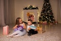 Boy and girl family opens Christmas gift new year holiday lights Christmas tree garlands Royalty Free Stock Photo