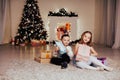 Boy and girl family opens Christmas gift new year holiday lights Christmas tree garlands Royalty Free Stock Photo