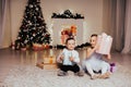 Boy and girl family opens Christmas gift new year holiday lights Christmas tree garlands Royalty Free Stock Photo