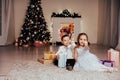 Boy and girl family opens Christmas gift new year holiday lights Christmas tree garlands Royalty Free Stock Photo
