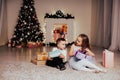 Boy and girl family opens Christmas gift new year holiday lights Christmas tree garlands Royalty Free Stock Photo