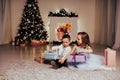 Boy and girl family opens Christmas gift new year holiday lights Christmas tree garlands Royalty Free Stock Photo