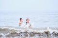 A boy and a girl are having fun playing in the sea.