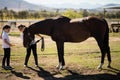 Boy and girl holding the reins and looking at the horse