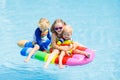 Kids on inflatable float in swimming pool. Royalty Free Stock Photo