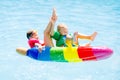 Kids on inflatable float in swimming pool. Royalty Free Stock Photo