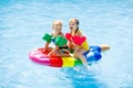 Kids on inflatable float in swimming pool. Royalty Free Stock Photo