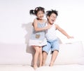 Boy and girl jumping and laughing on sofa