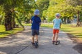 Boy and girl on kick scooters in park. Kids learn to skate roller board. Little boy skating on sunny summer day. Outdoor Royalty Free Stock Photo