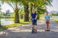 Boy and girl on kick scooters in park. Kids learn to skate roller board. Little boy skating on sunny summer day. Outdoor Royalty Free Stock Photo