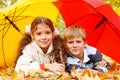 Boy and girl lying on yellow leafage