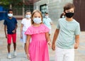 Pair of young people in masks walking hand in hand