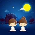 Boy and girl meditating at temple with night scene.