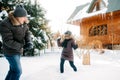 Boy and girl outdoors on a winter walk playing snowballs Royalty Free Stock Photo