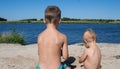 A boy and girl play with sand on the river bank Royalty Free Stock Photo