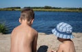 A boy and girl play with sand on the river bank Royalty Free Stock Photo