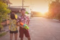Teenagers play squirt gun together on Songkran festival in Thailand over sunset Royalty Free Stock Photo