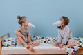 Boy and girl playing in bedroom with party cone hats, wearing them like beaks Royalty Free Stock Photo