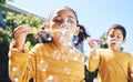 Boy, girl and playing with bubbles outdoor in garden, backyard or park with happiness, family or siblings. Children Royalty Free Stock Photo
