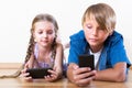 Boy and girl playing with mobile phones Royalty Free Stock Photo