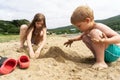 Boy and girl are playing with sand on the beach. Royalty Free Stock Photo