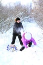 A boy and a girl are playing with snow