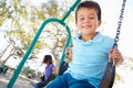 Boy And Girl Playing On Swing In Park Royalty Free Stock Photo