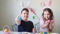 boy and girl are preparing cookies for easter, laughing. Having fun on Easter egg hunt. Child boy and girl wearing bunny