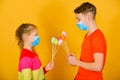 A boy with a girl in a protective mask from a coronavirus give each other Easter eggs on a holiday Royalty Free Stock Photo