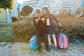 Boy and girl pupils in primary school with a digital tablet. Outdoor background, children with school bags, look at the tablet. Ed