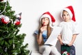 Boy and a girl in a red cap write a letter to Santa Claus Royalty Free Stock Photo