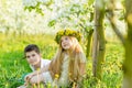 A boy and a girl are resting in a blooming garden in the spring Royalty Free Stock Photo