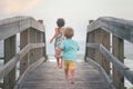 Boy and girl running on wooden deck on the beach Royalty Free Stock Photo