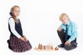 Boy and girl in school uniform playing chess, looking at camera, isolated white background Royalty Free Stock Photo