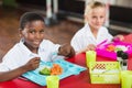 Boy and girl in school uniforms having lunch in school cafeteria Royalty Free Stock Photo