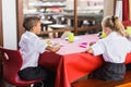 Boy and girl in school uniforms having lunch in school cafeteria Royalty Free Stock Photo