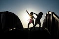 Boy and girl silhouettes dancing on a bridge Royalty Free Stock Photo