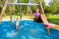 Boy and girl singing on swings